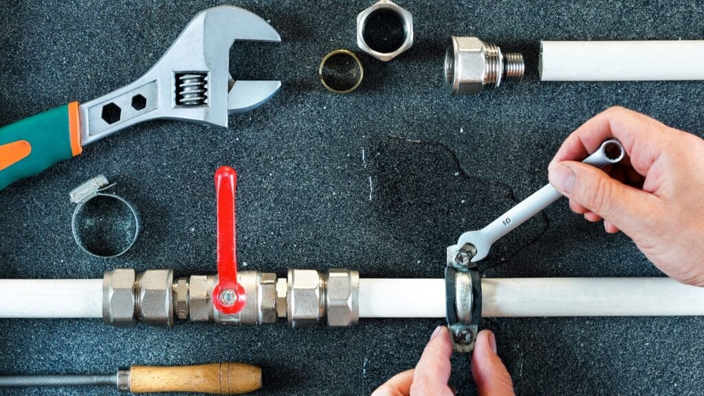 Plumber repairing a pipe valve with an adjustable wrench in Loma Linda