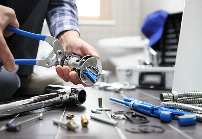 Technician repairing a plumbing fixture with professional tools in Loma Linda