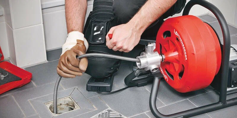 Plumber using a drain-cleaning machine in Loma Linda
