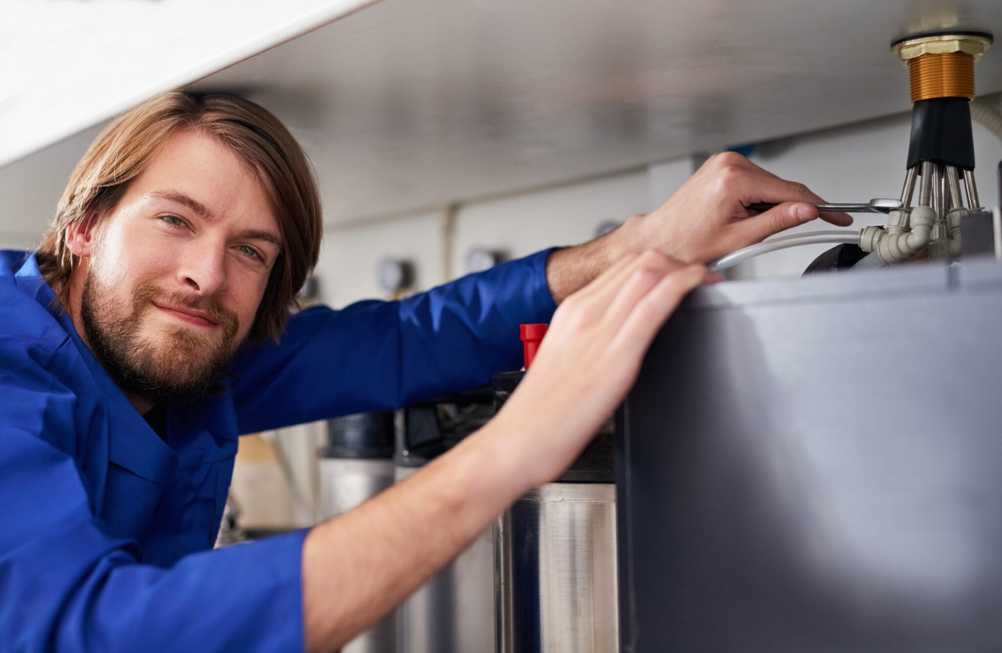 Technician servicing a residential water heater tank in Loma Linda